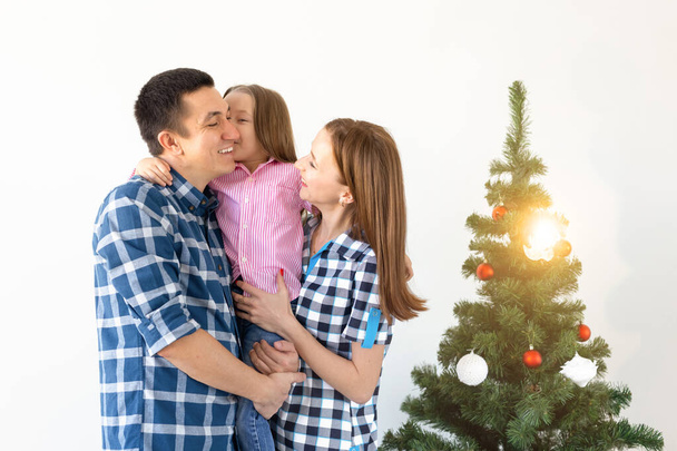 Urlaub, Geschenke und Christbaumkonzept - kleine Familie feiert Weihnachten gemeinsam. - Foto, Bild