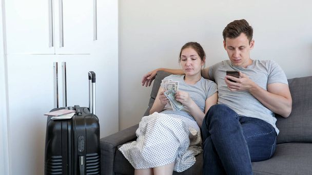 Man and woman choose budget hotel for rest counting money using smartphone. - Photo, Image