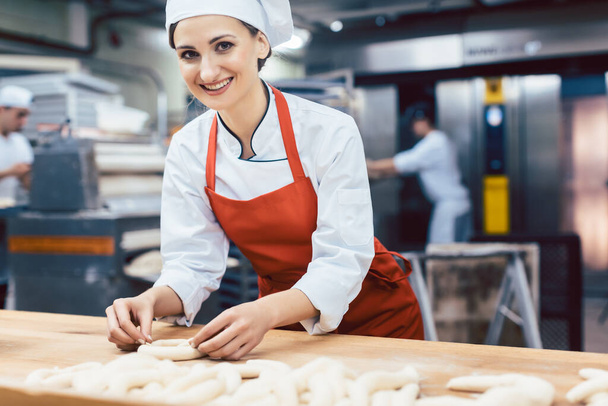 Baker woman forming pretzels and bread - Photo, Image