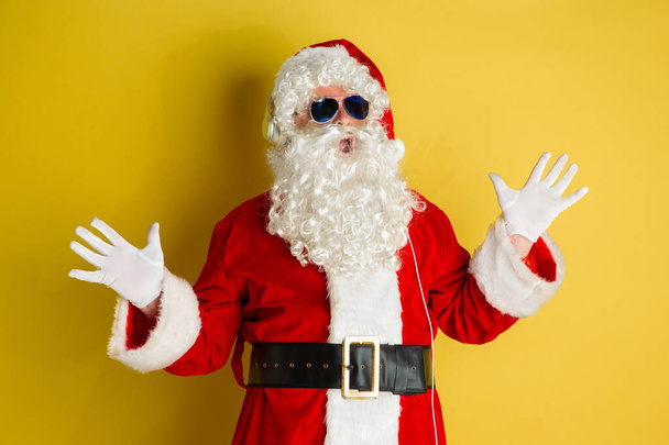 Santa Claus with modern eyeglasses isolated on yellow studio background - Фото, зображення