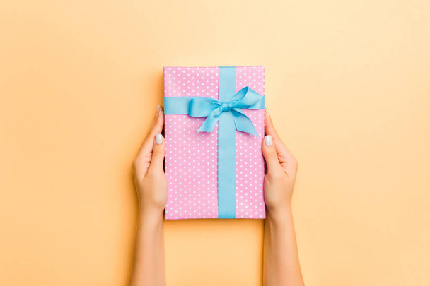 Flat lay of woman hands holding gift wrapped and decorated with  - Foto, afbeelding