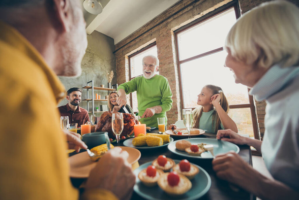 Big family thanksgiving day celebration retired man cut roast chicken meat relatives small little kid sit table enjoy november feast tradition meal with corn harvest pie wine in house - 写真・画像