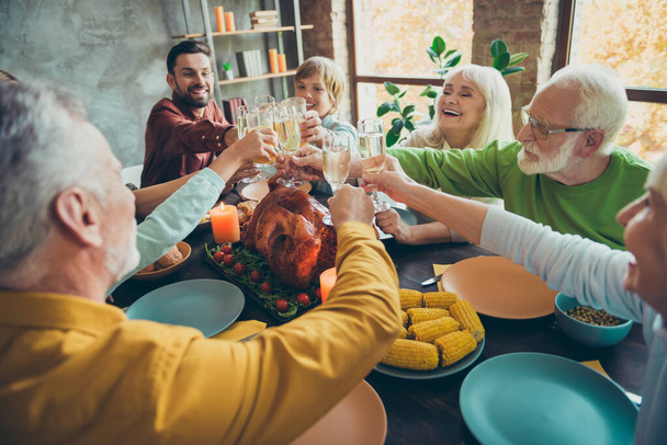 Big happy family sit table celebrate october holiday thanksgiving day hold glass of champagne clink have meal corns harvest roasted meat gathering small kids pensioners in house - Foto, Imagem