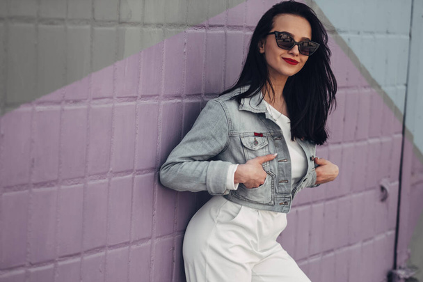 Beautiful Brunette Girl in Sunglasses White Pants and Jeans Jacket, Red Lipstick - Photo, Image