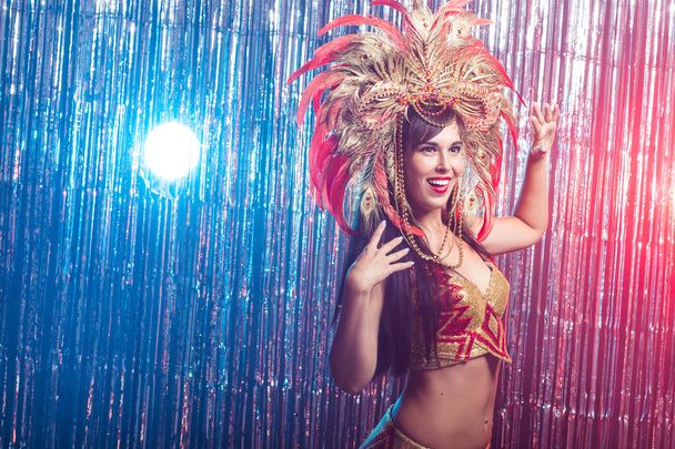 Karnevál, táncos és üdülési koncepció-portré egy szexi nő egy színes pazar karneváli toll öltöny. A női táncos éjszakai élete - Fotó, kép