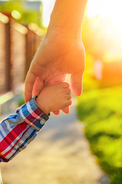 the parent holding the child's hand with a happy background - Foto, afbeelding