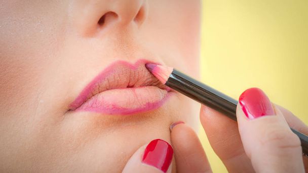 Make-up professionelle Künstlerin Lippenstift mit Bleistift auf die Lippen auftragen - Foto, Bild