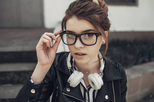 Outdoor Summer Portrait of Young Beautiful Girl in Black Leather Jacket and Trendy Black Glasses - Photo, Image