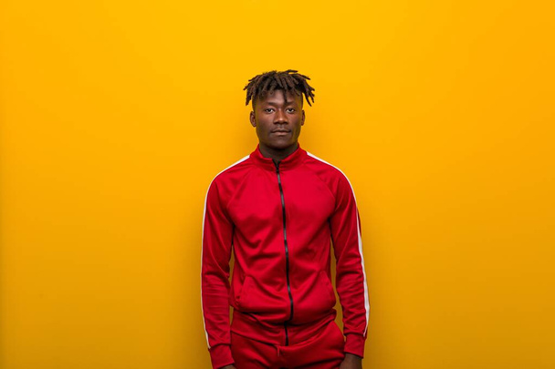 Giovane uomo sportivo africano in piedi contro uno sfondo giallo
 - Foto, immagini