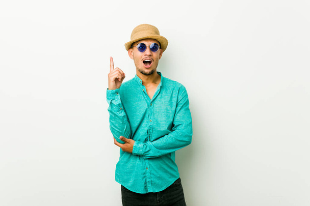 Joven hombre hispano vistiendo una ropa de verano que tiene una gran idea, concepto de creatividad
. - Foto, imagen
