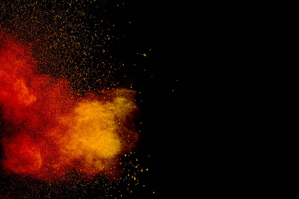 Orange red  powder explosion on black background.Orange red color dust splash clouds. - Foto, imagen