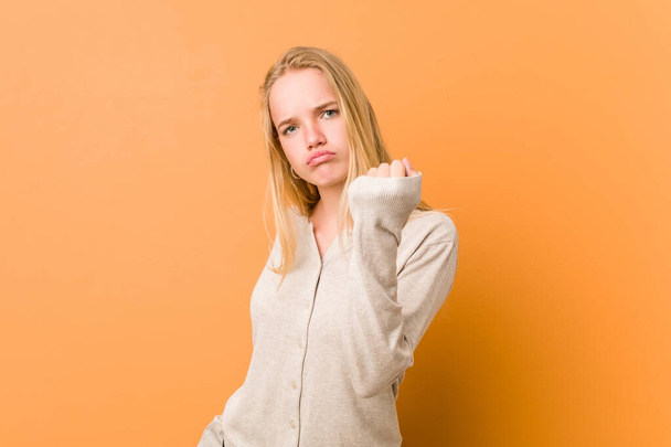 Cute and natural teenager woman showing fist to camera, aggressive facial expression. - Photo, image