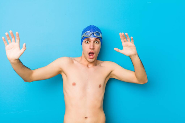Young swimmer man being shocked due to an imminent danger - Photo, Image