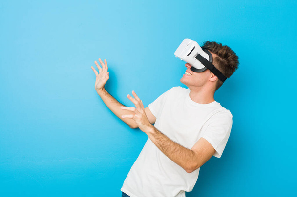 Έφηβος Καυκάσιος άνθρωπος χρησιμοποιώντας ένα εικονικό γυαλιά πραγματικότητας - Φωτογραφία, εικόνα