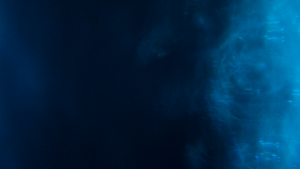 Niebieski obiektyw rozbłyskuje na czarnym tle - Materiał filmowy, wideo