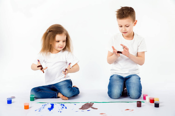 Two pretty child friends boy and girl are drawing pictures by paints - Zdjęcie, obraz