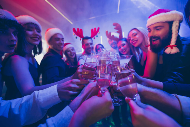 En iyi arkadaşların fotoğrafında şirket şirketinin elinde köpüklü şarap kadehleri var. Yeni yılı sayıyor. Yeni yıl kıyafetlerini giyip Noel Baba şapkası takıyorlar. - Fotoğraf, Görsel