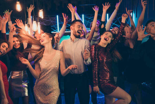 Foto di eccitati pazzi allegri allegri persone allegre aziendali vestite in abiti formali che celebrano il suo amico compleanno cantando urlando gridando ballando sotto le luci del neon
 - Foto, immagini