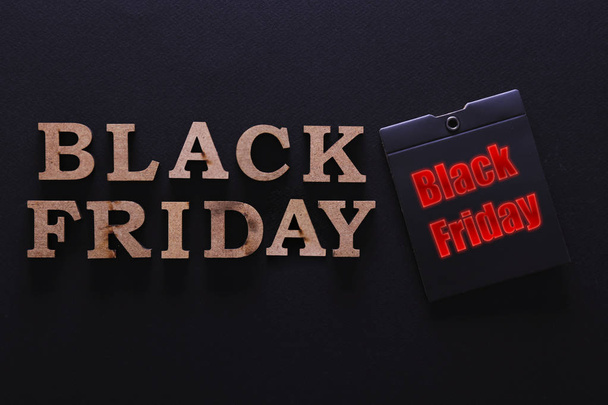 black friday themed concept with objects on black paper textured background. - Foto, Imagen