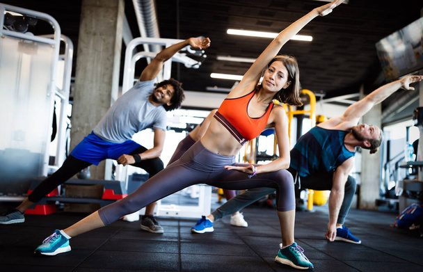 Happy fit people exercising, working out in gym to stay healthy together - 写真・画像