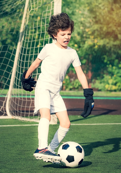 Summer soccer tournament for young kids. football club. emotions and joy of the game. Young goalie. Kids - soccer champion. Boy goalkeeper in football sportswear on stadium with ball. Sport concept. - Foto, Bild