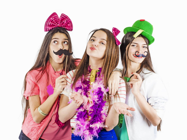 Portrait of three beautiful girls with festive make-up, hairstyle, accessories, props - Photo, Image