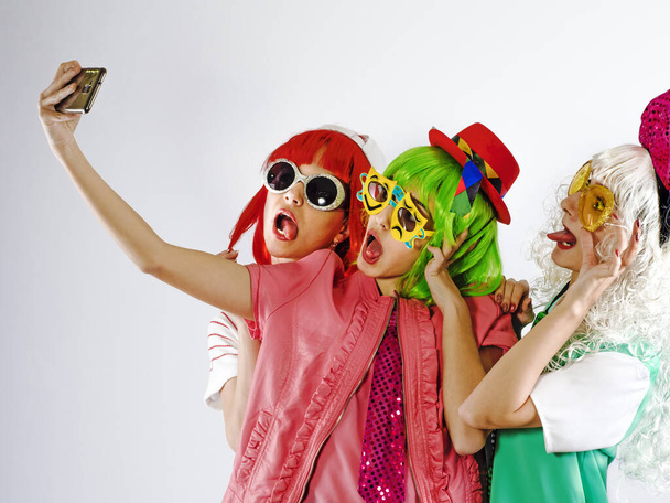 Cheerful maiden company makes selfies. White background. - Фото, изображение