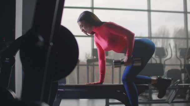 Mulher está fazendo exercício com halteres no ginásio
 - Filmagem, Vídeo