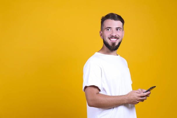Perfectly groomed bearded man with fashionable hairstyle posing over yellow background. - Fotoğraf, Görsel