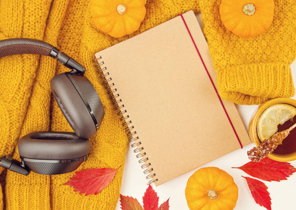 Composição plana do outono com folhas de outono, xícara quente de chá e um suéter laranja lanoso quente
 - Foto, Imagem