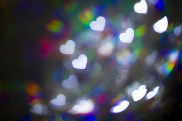 虹色の光の背景に白いハート型のボケ - 写真・画像