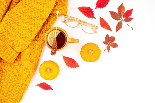 Плоская осенняя композиция с осенними листьями, горячим чаем и теплым шерстяным апельсиновым свитером
 - Фото, изображение
