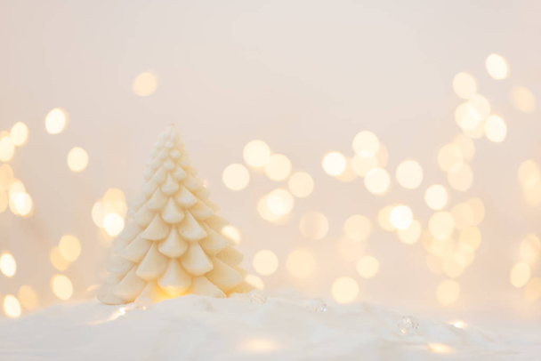 White fir tree candle with defocused lights background. Christmas greeting card. Christmas or New Year celebration concept. Copy space - Fotó, kép