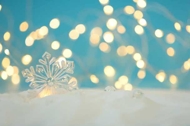 Snowflake with defocused lights against blue background. Christmas greeting card. Christmas or New Year celebration concept. Copy space - Zdjęcie, obraz