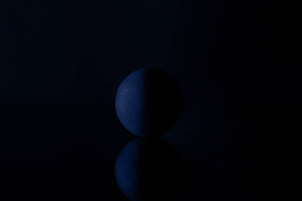 Black stone ball on a dark background. Design idea. - 写真・画像