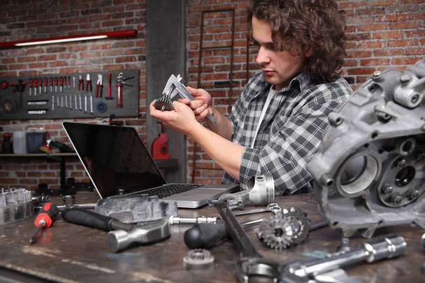 man work with caliper measure the motor gear, study on the compu - Foto, immagini