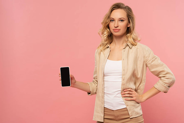 Houkutteleva nainen tilalla älypuhelin tyhjä näyttö eristetty vaaleanpunainen
 - Valokuva, kuva