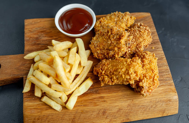 fried chicken on a black background - Фото, зображення