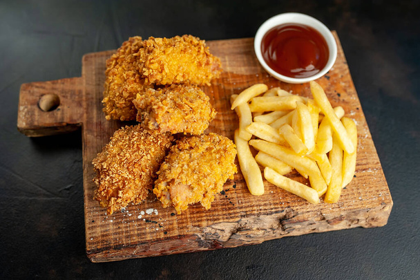 курица и картофель фри на черном фоне
 - Фото, изображение