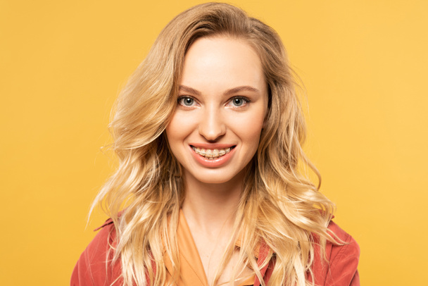 Portrait of smiling blonde woman isolated on yellow - Zdjęcie, obraz