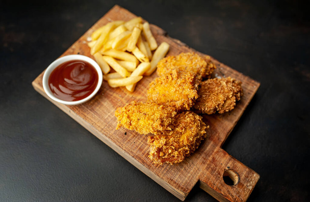 pollo frito y canela sobre fondo negro
 - Foto, imagen