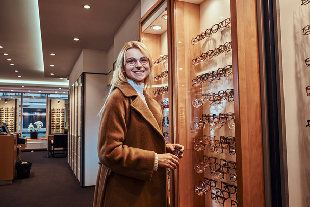 Γυναίκα επιλέγει νέα πλαίσια για τα γυαλιά - Φωτογραφία, εικόνα
