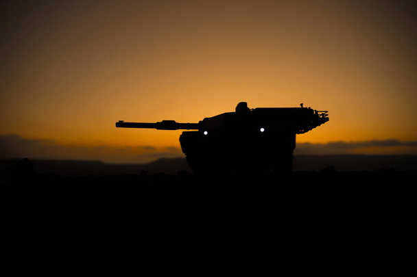 War Concept. Armored vehicle silhouette fighting scene on war fog sky background. American tank at sunset. - Photo, Image