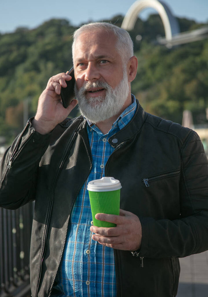 Thoughtful senior man talking over mobile phone stock photo - Zdjęcie, obraz