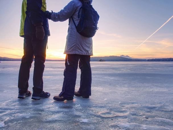 Couple, man and woman walking on ice on a frozen lake - Photo, Image