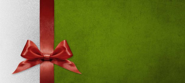 Χριστουγεννιάτικη κάρτα δώρου με κόκκινη κορδέλα φιόγκο σε πράσινο και ασημί πλάτη - Φωτογραφία, εικόνα