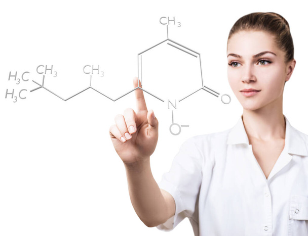 Young female doctor pointing on chemical formula. - Фото, зображення
