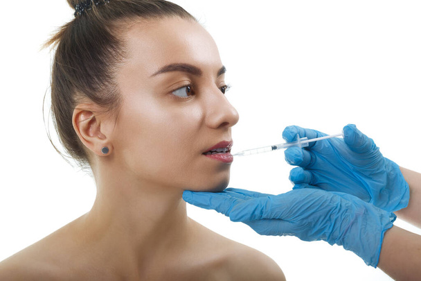 Facial Beauty Injections. Portrait Beautiful Young Woman Receiving Hyaluronic Acid Injection. Closeup Of Hands In Gloves Holding Syringe Near Attractive Female Face. - Foto, Imagen