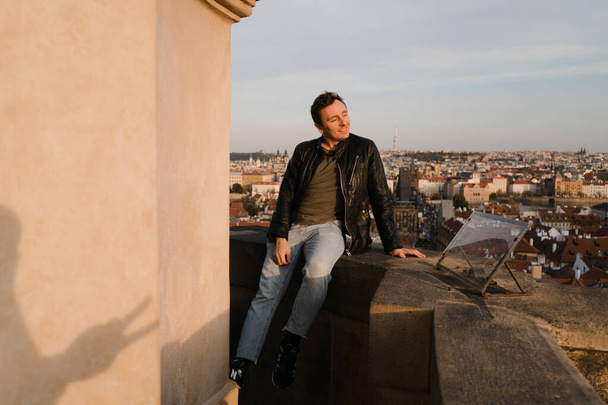 Ευτυχισμένος άνθρωπος ξεκινήσει νέα ζωή κοιτάζοντας το κέντρο της Πράγας και Charles Bridge άποψη από ψηλά και χρησιμοποιώντας το τηλέφωνο για να τραβήξετε μια φωτογραφία selfie - Φωτογραφία, εικόνα