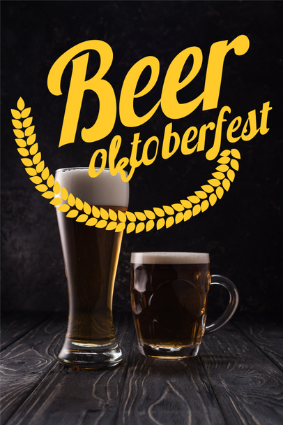 glass and mug of fresh light beer with foam on wooden table with yellow beer Oktoberfest lettering - Фото, зображення